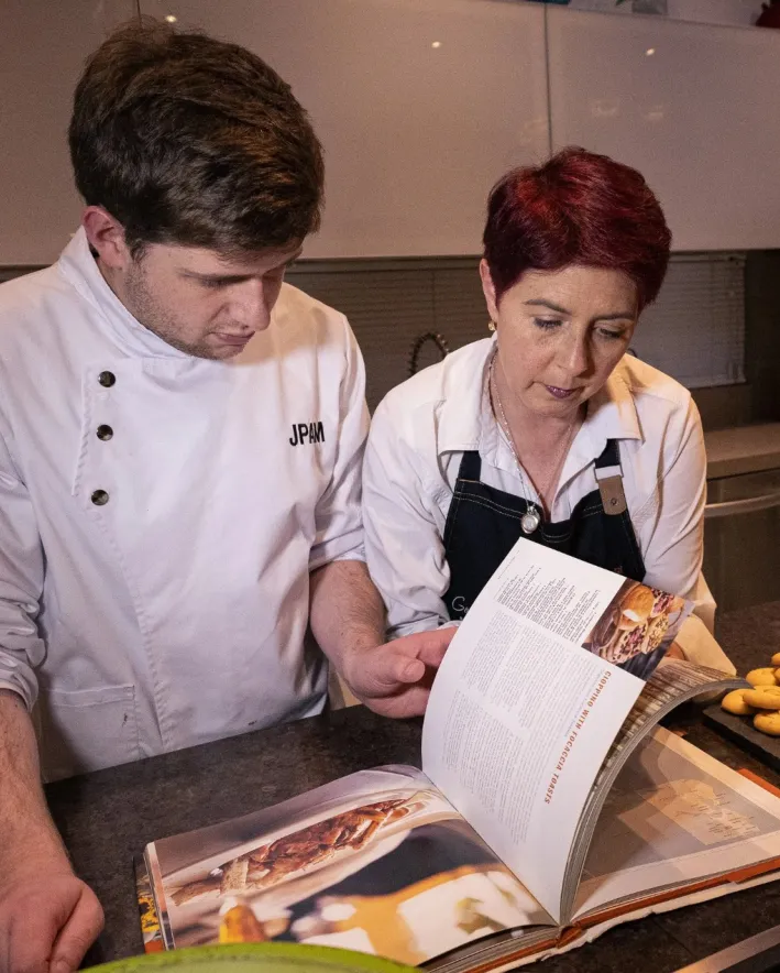 Juan Pablo Andrade y Kathy Matuk revisando un libro de cocina